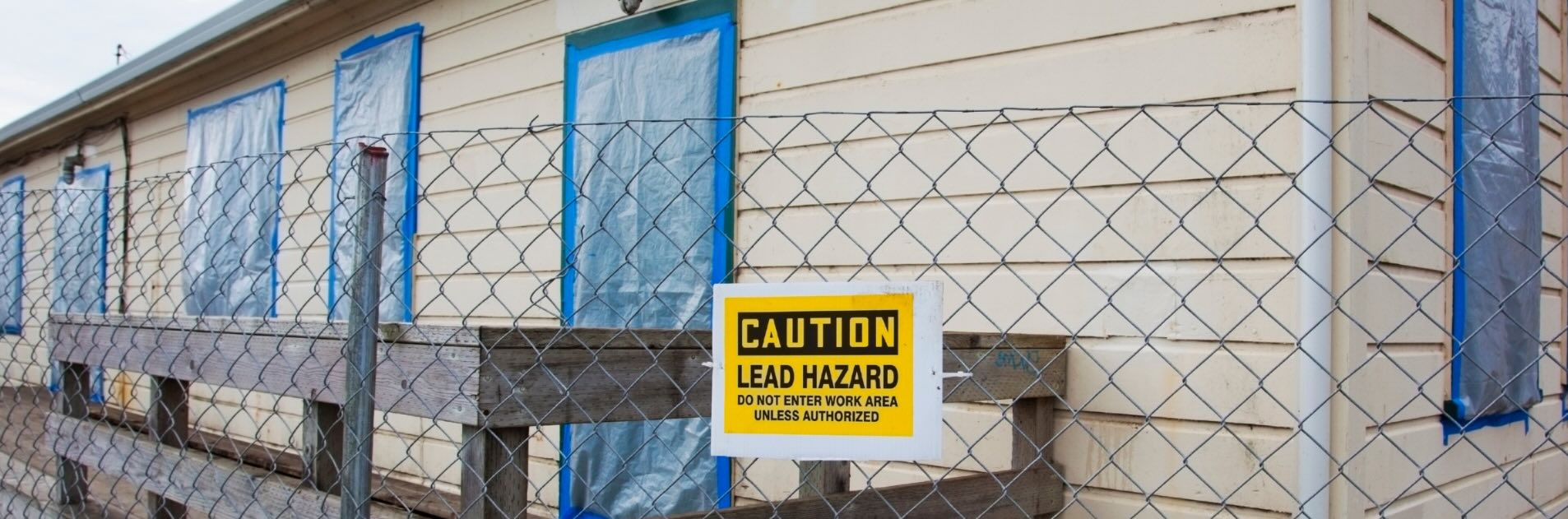 a building with "caution, lead hazard" warning